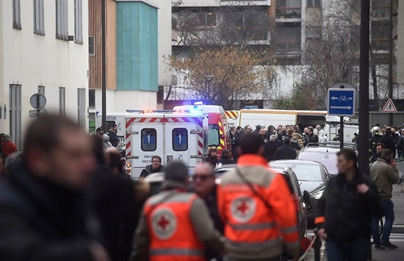 Lực lượng cứu hỏa và đám đông tập trung tại hiện trường vụ tấn công. Các nhân chứng cho hay, họ nghe thấy tiếng súng nổ liên tiếp tại trụ sở tạp chí Charlie Hebdo của Pháp.