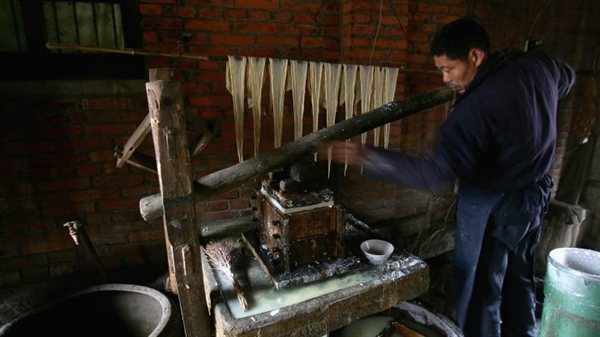 Một công nhân Trung Quốc sử dụng một kỹ thuật truyền thống để làm đậu phụ tại nhà máy của gia đình anh ta vào ngày 6 tháng 2 năm 2005 tại Trung Quốc.