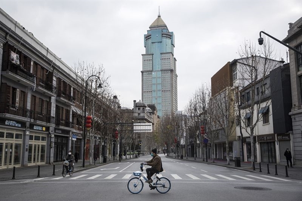 Người đi xe đạp đi qua đoạn đường trống ở Vũ Hán vào ngày 08/02. Nguồn: Bloomberg.