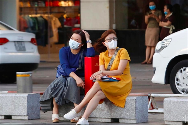FILE PHOTO: Women sit in a street as they wear face masks in Ho Chi Minh, Vietnam February 13, 2020. REUTERS/Yen Duong