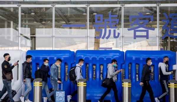 Travellers wearing face masks walk outside a terminal building at Hong Kong International Airport. Photo: Bloomberg