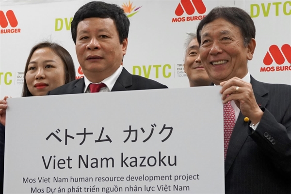 Mos Food Chairman Atsushi Sakurada, right, introduces the training program in Vietnam in October. (Photo by Ryosuke Eguchi)