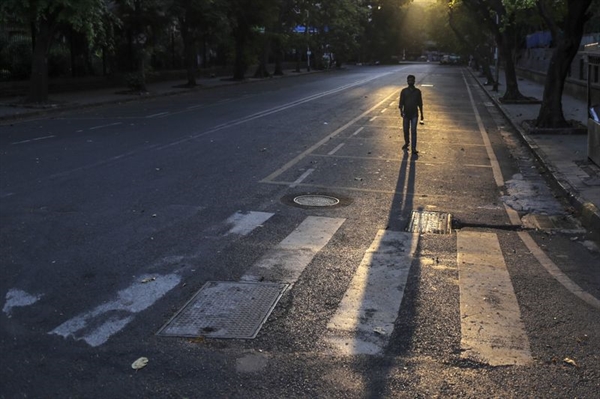 Một người đàn ông đang bước đi cô độc trên con đường vắng lặng tại Mumbai, Ấn Độ.
