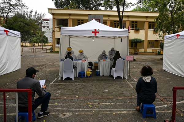 Poeple wait at a rapid testing center near the Bach Mai hospital in Hanoi on March 31.Photographer: Manan Vatsyayana/AFP via Getty Images