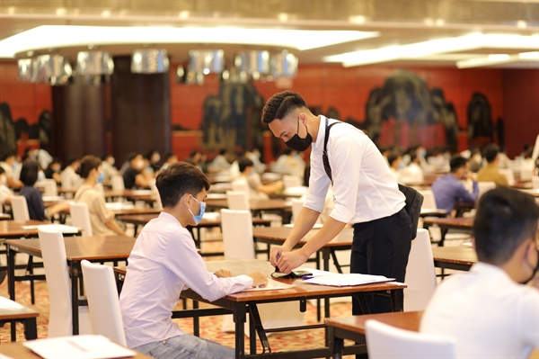 Candidates wear face masks and keep a distance from one another during the GSAT in Hanoi on June 20, 2020. Photo: S.S. / Tuoi Tre